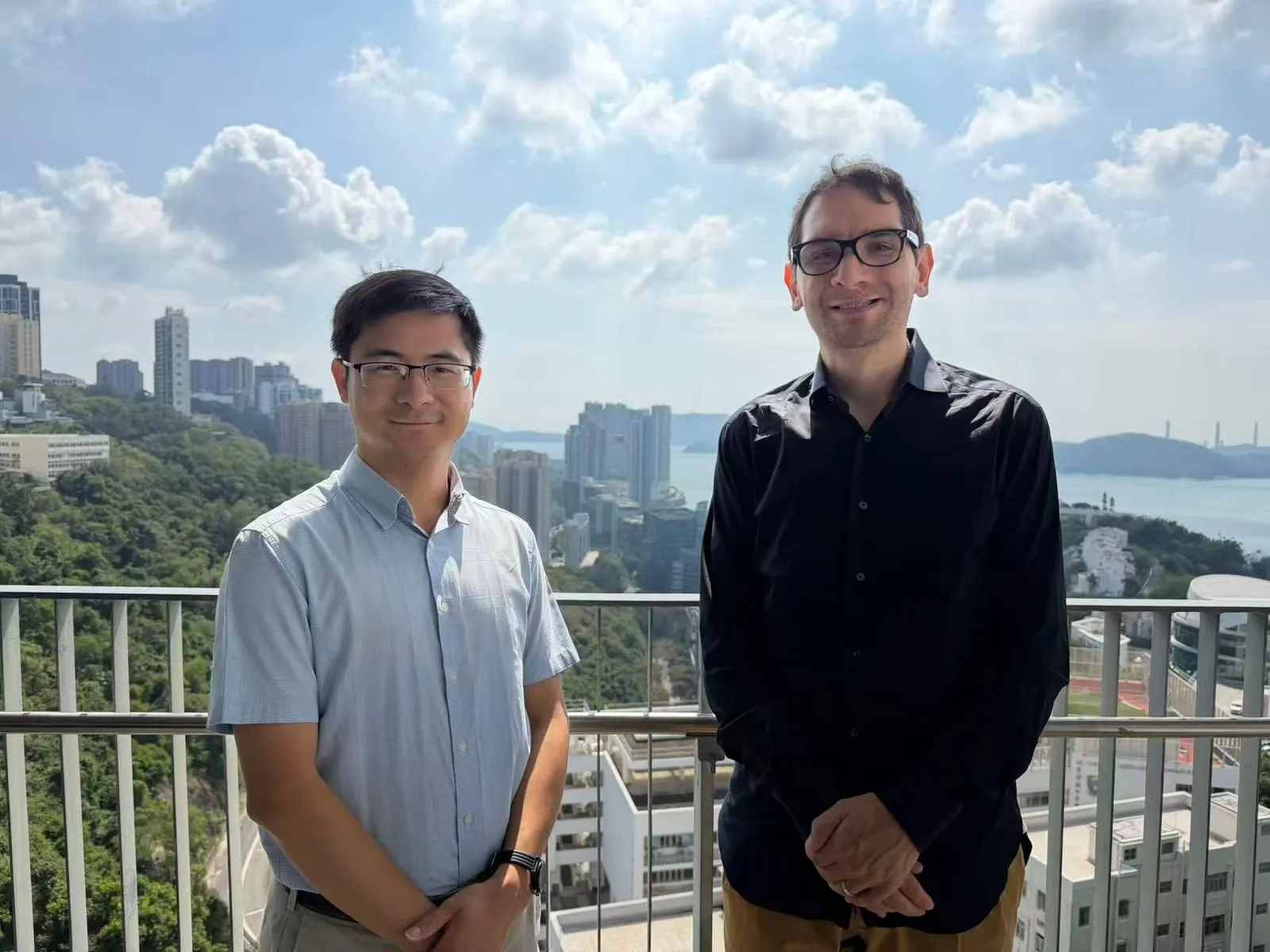 Ciro Chiappini with a host on a terrace overlooking Hong Kong’s hillside towers and the sea