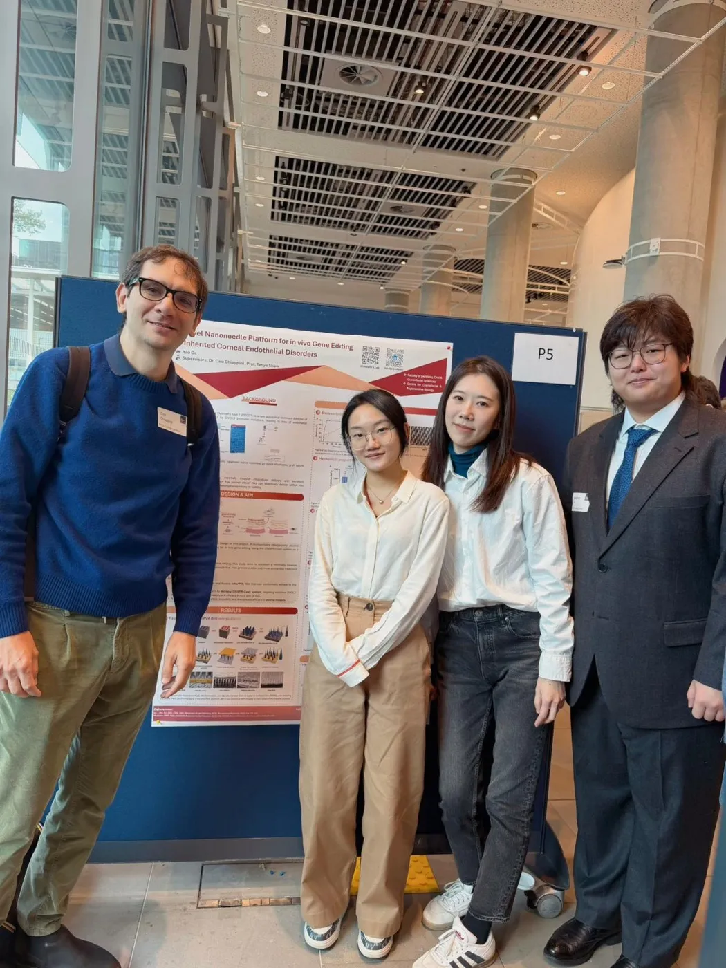 Ciro Chiappini with three lab members in front of a research poster on a nanoneedle platform for gene editing.